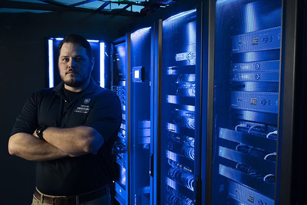 Center for Cybersecurity student standing in a server room