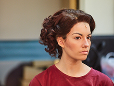 A student backstage preparing for UWF Theatres production of Evita