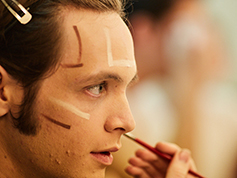 Student applying makeup for UWF Theatres production of Evita