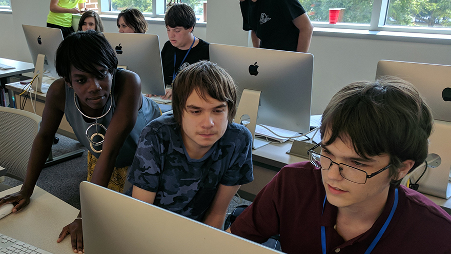 students at cybersecurity camp working out a problem on a computer