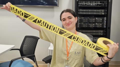 Girl holding a roll of caution tape.