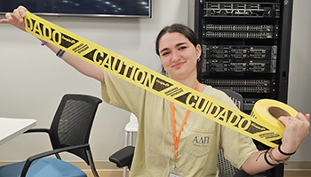 Girl holding a roll of caution tape.