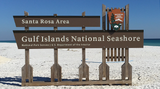 Santa Rosa Area Gulf Islands National Seashore sign on the beach.