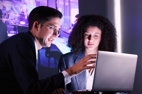 Two AI professionals reviewing data on a laptop