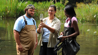 Dr. Jane Caffrey and two students examining biological samples from wetlands