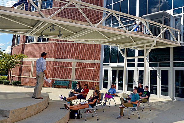 students listening to a lecture outside of uwf building 4