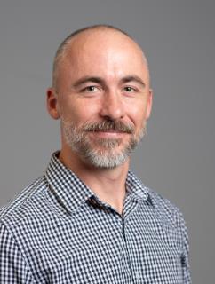 A man with a beard wearing a black and white checked shirt