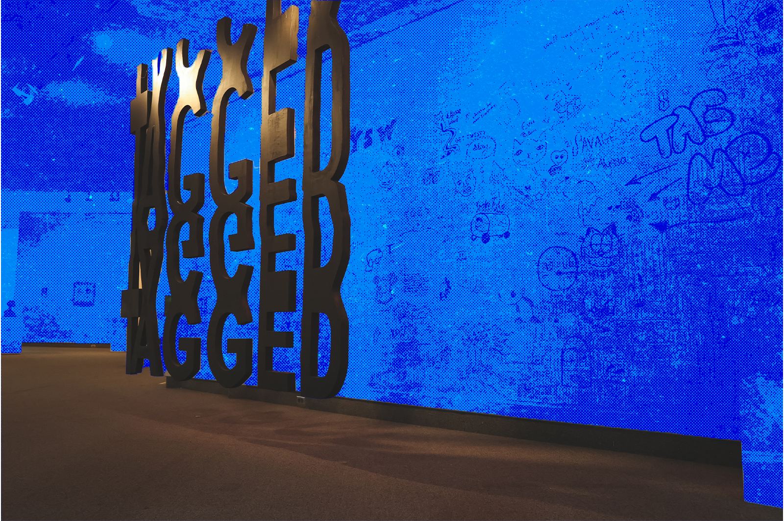 TAGGED sign in front of a wall covered in doodles, featuring a blue half-tone overlay