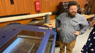 Person standing in front of laser machine in the Makerspace