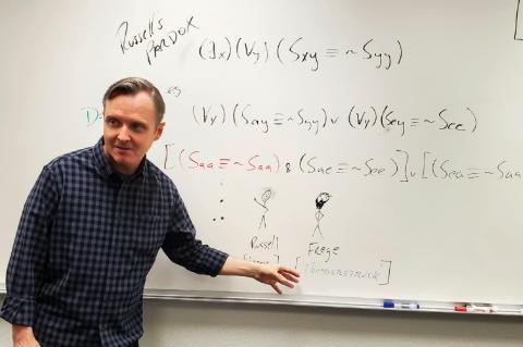 An instructor showcasing a logic formula.