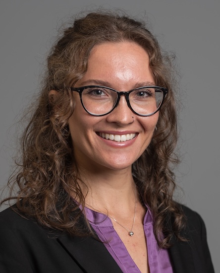 Headshot of Julianna Costanzo in a purple top and black sweater