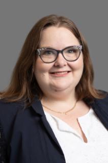 Dr. Melissa Dow in a black jacket with a white top.