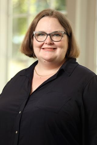 Dr. Melissa Dow in a black jacket with a white top.