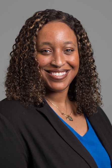 A staff member in a blue top with a black jacket.