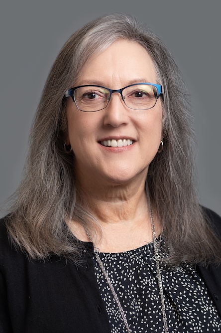 A staff member with a polka dot top and black sweater.
