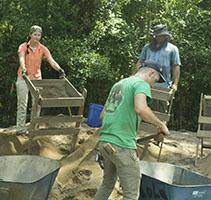 students sifting through dirt at dig site