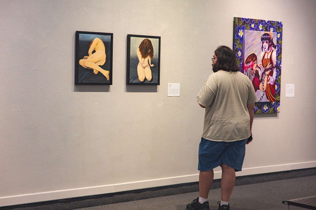 A person looking at art on a wall.