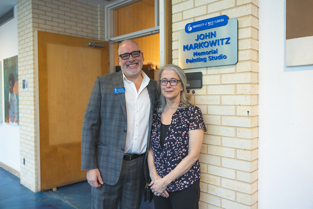 Dr. David M Earle and Cheri Markowitz in front of John Markowitz memorial plaque