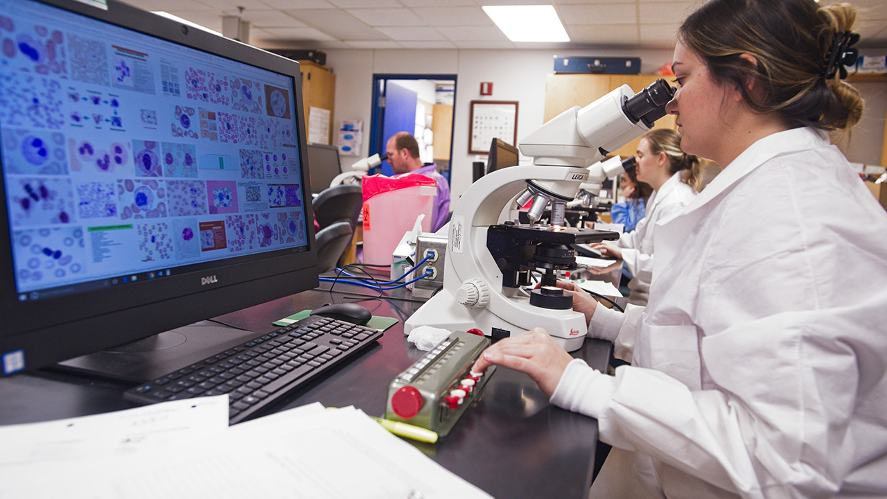 MLS student works with a microscope in class