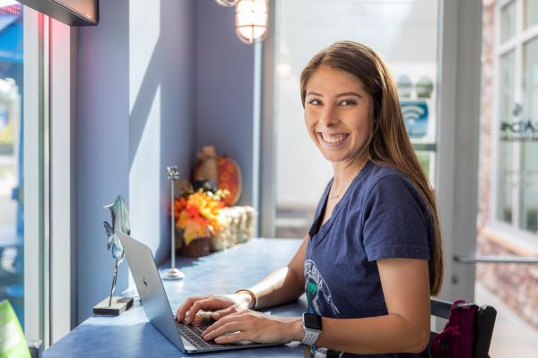 Smiling student using a laptop