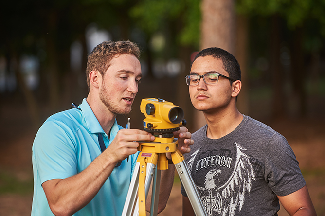 Two students looking through a survey tool