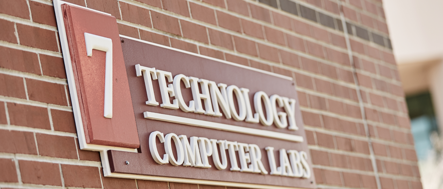 Brick wall building signage stating 7 Technology and Computers Labs.