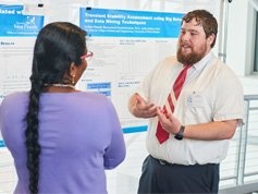Ramachandran talking to student presenting his research