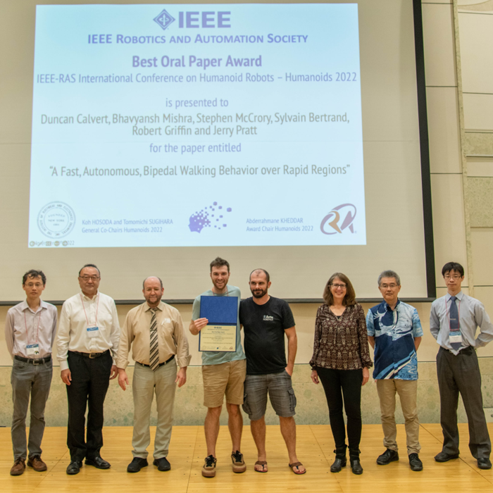 Students standing in front of presentation to receive award