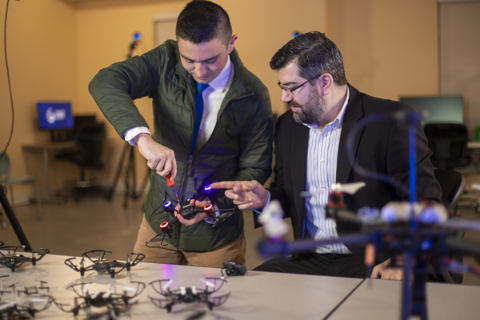 teacher works with student on drone technology