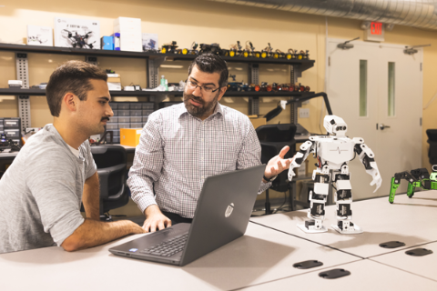 teacher with student in robot lab