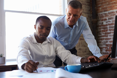 Leader mentoring student in business office