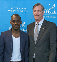 Joseph FanFan and Captain Kevin Miller standing together in front of a University of West Florida press backdrop.