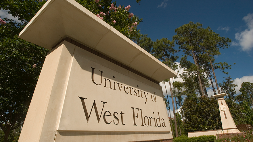 University of West Florida campus entrance sign in front of trees.