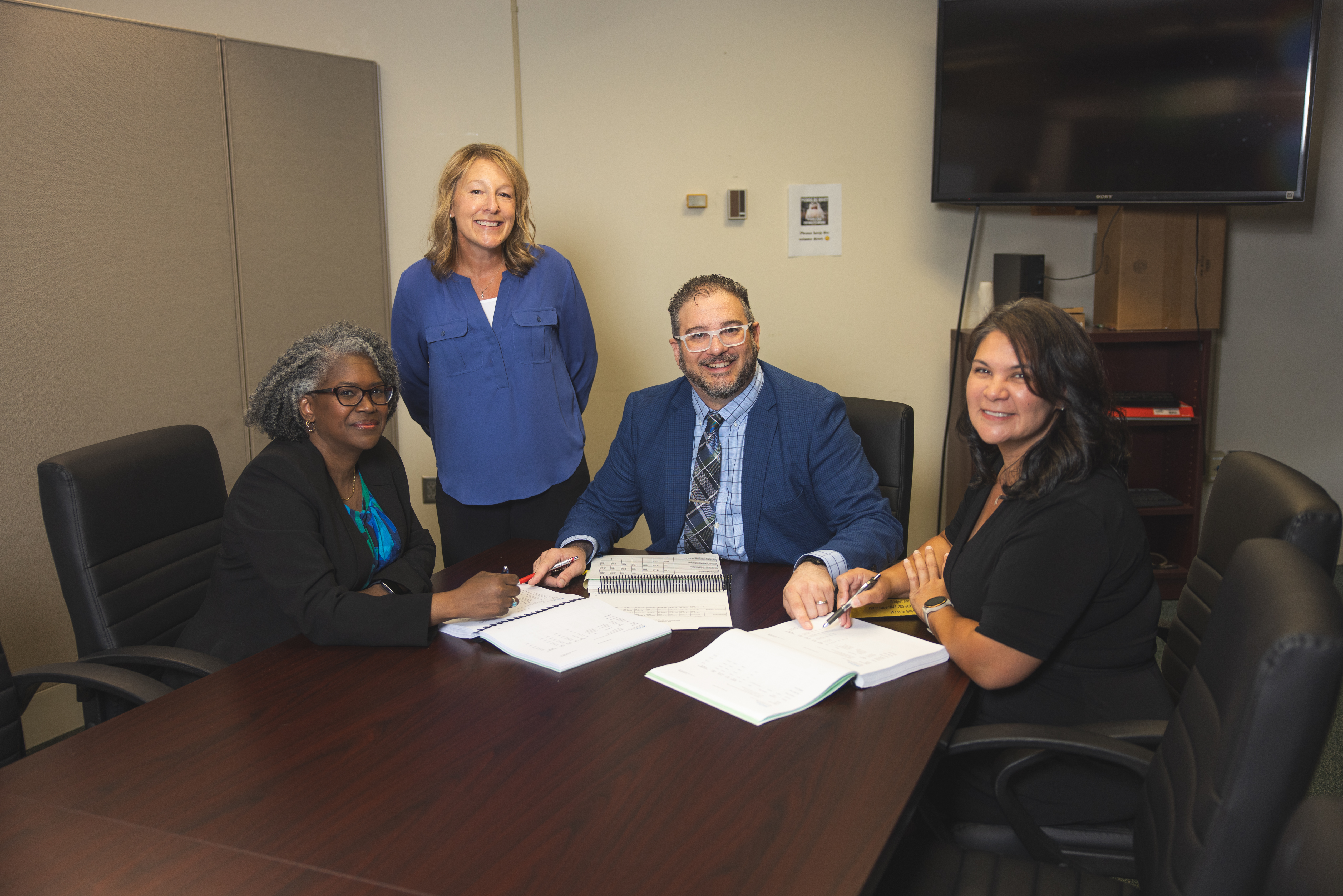 4 individuals sitting at a conference table.