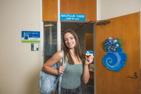 Student presenting their ID Card, standing in the ID Card Services office