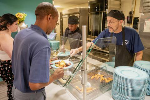 students in line having food put on their plate by Argo Food Co staff