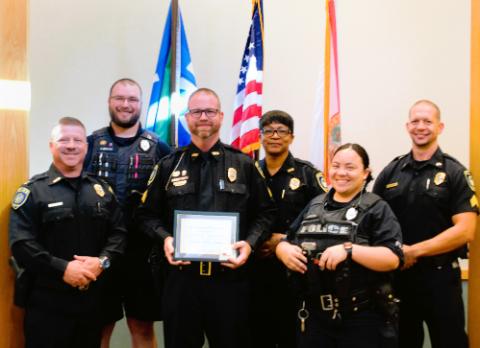 six uwf police officers, one posing with a distinguished service award