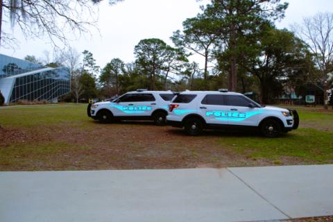 two UWF police cars positioned in the median on campus