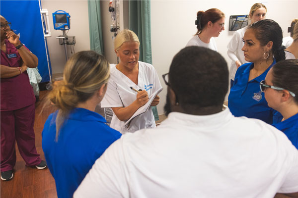 Nursing student leading an exercise and practicing leadership skills in the nursing simulation lab.