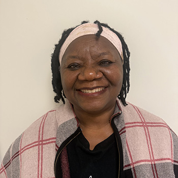Kate Peabody smiling at the camera wearing a flannel jacket and a headband.