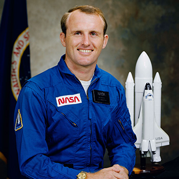 James Buchli posing in NASA uniform