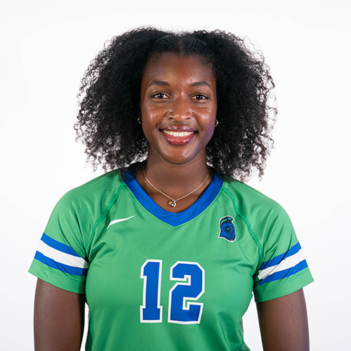 Gabi Moulton smiling at the camera wearing a green UWF volleyball jersey with the number 12.