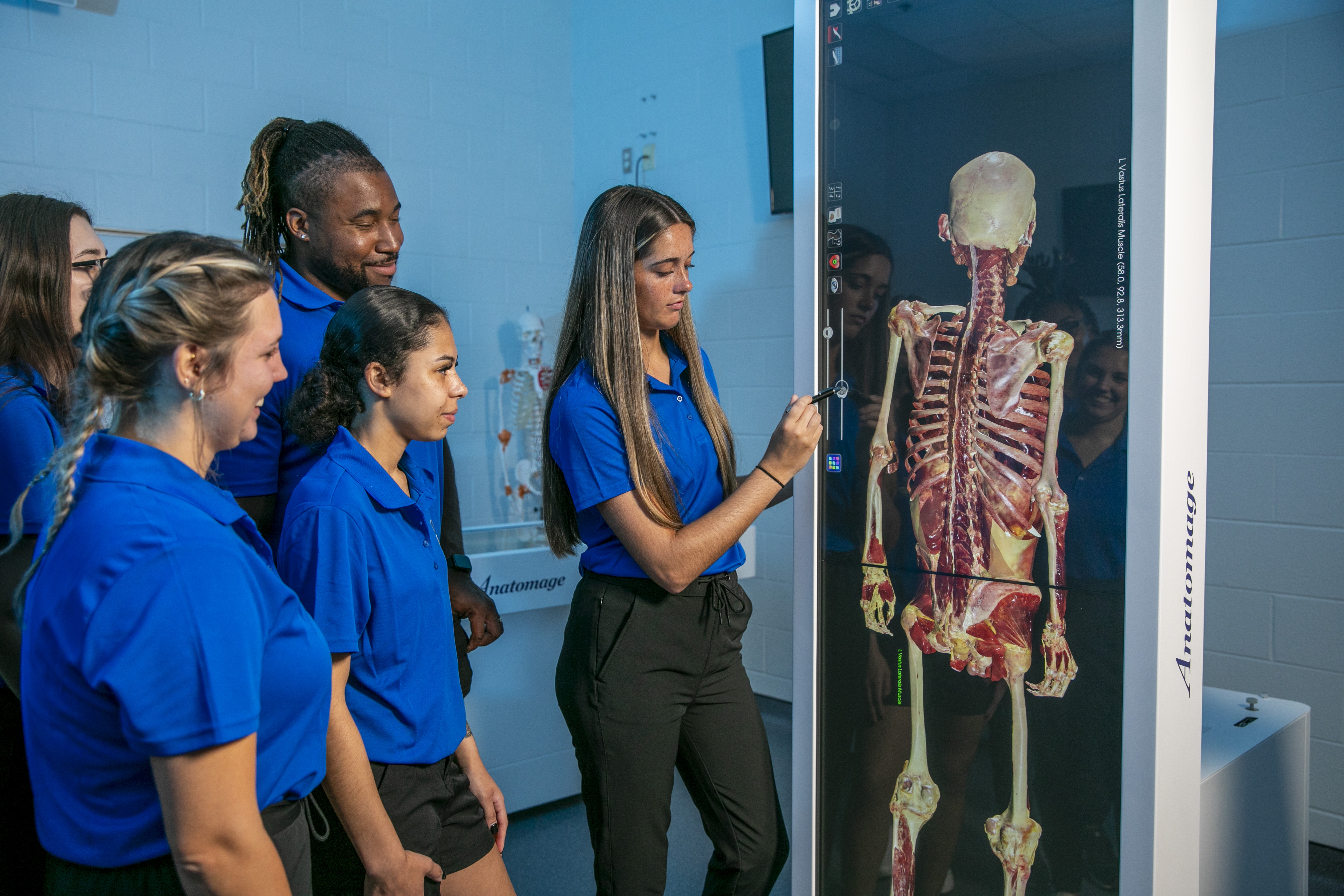 Students standing in front of an anatomage simulated cadaver table.