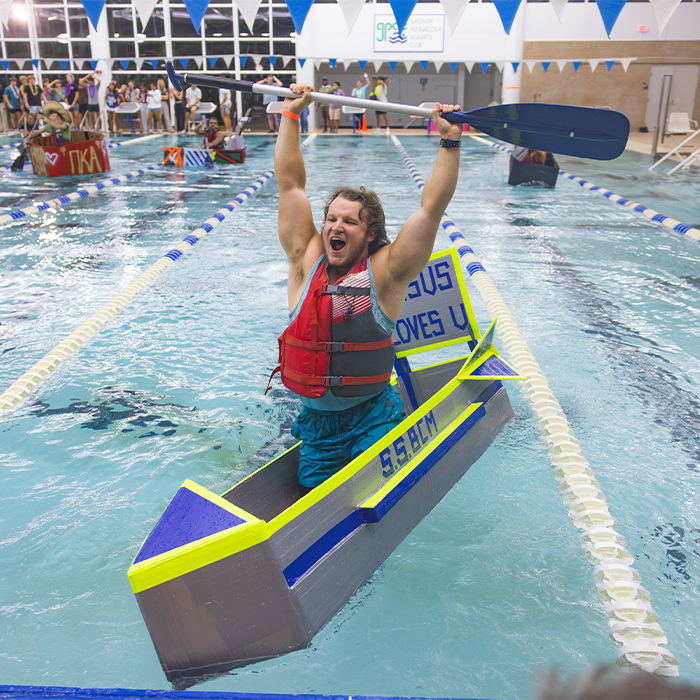 Student finishing first on cardboard boat race