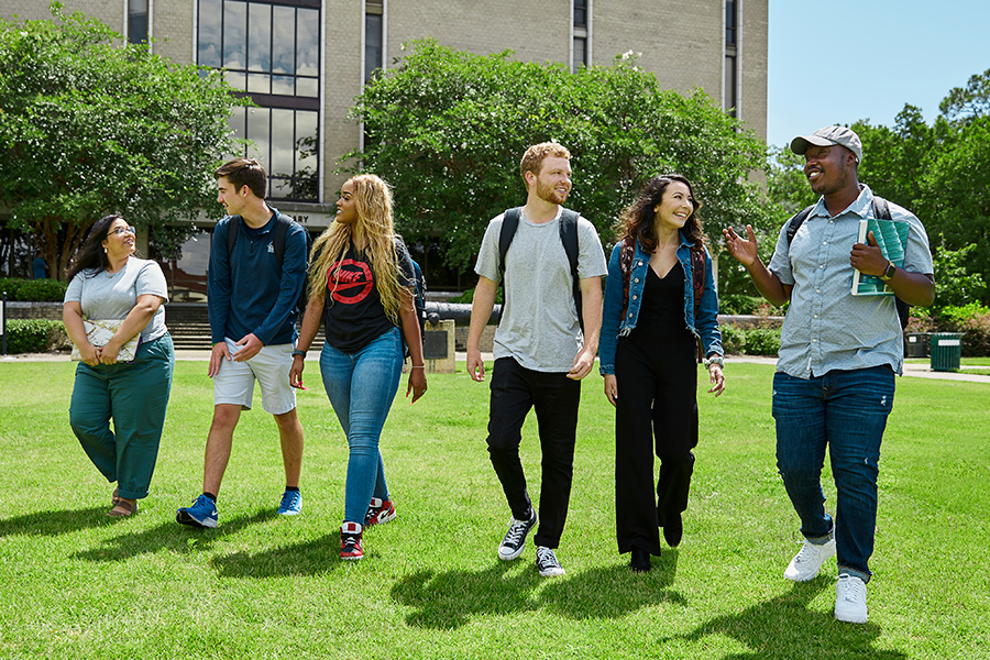 Students walk across Cannon Green in front of the Pace Library