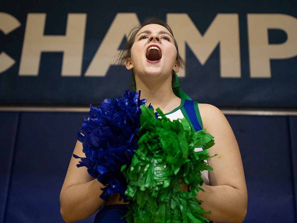 UWF cheerleader in front of a banner saying Champion