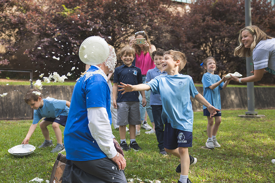 Happy child throws a pie in the UWF Pie-a-Dean Challenge