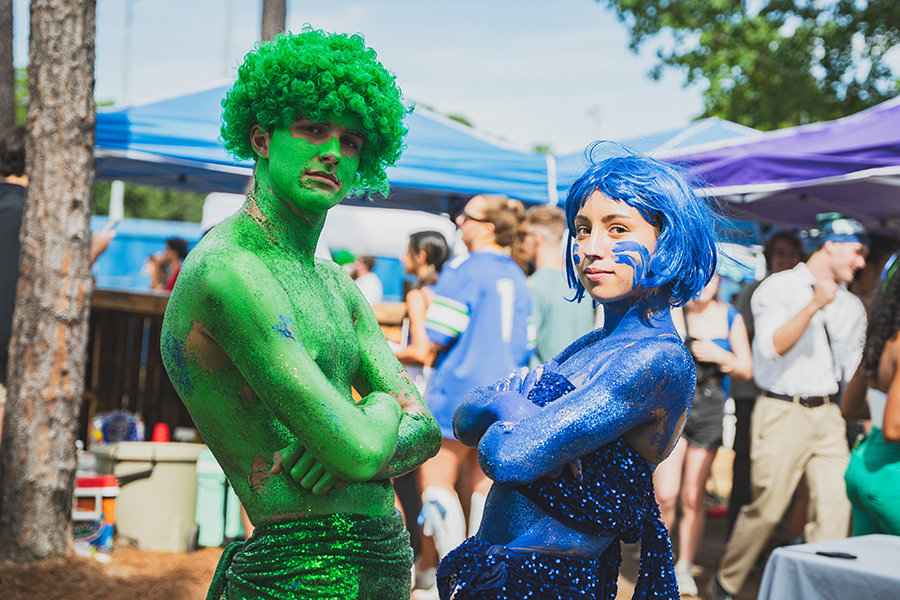 Two students in green and blue body paint celebrate Homecoming