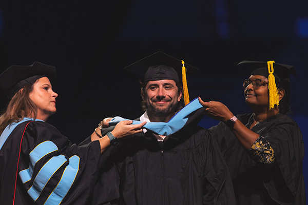 An Argo is hooded at Fall Commencement.