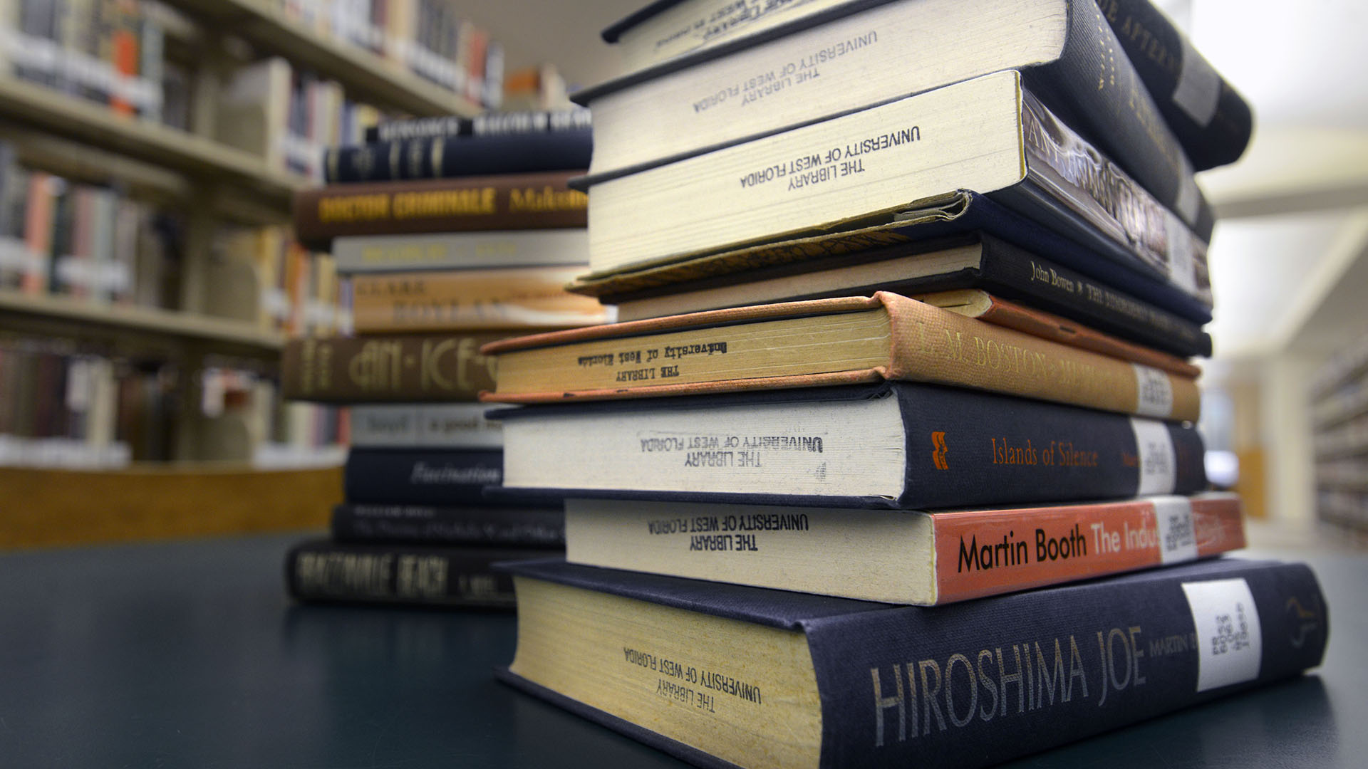 Library book display featuring two stacks of books on a table.